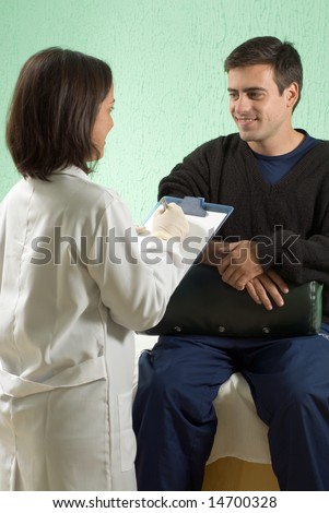 A female doctor writing on her clipboard as she interviews a patient - vertically framed