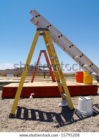 Industrial step ladders at a desert new home construction site.