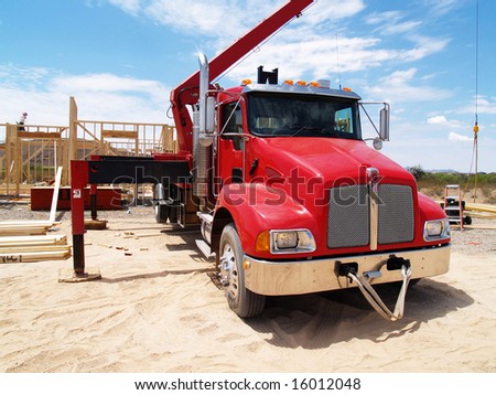 Close up of red Semi Truck with Construction Crane. Horizontally framed shot.