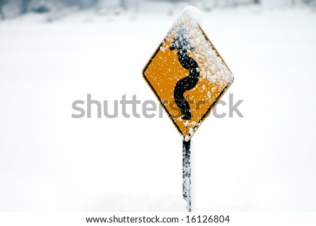 Windy road sign with snow on it. Horizontally framed photo.
