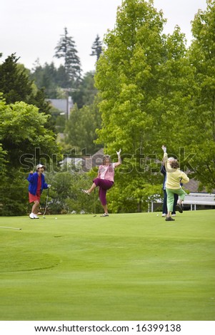 Group of four women celebrating while playing golf. Vertically framed photo.