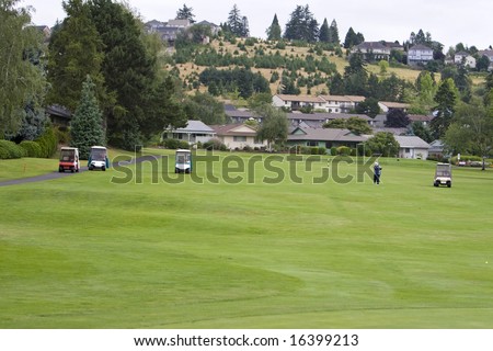 Golf course with golf carts on it. Horizontally framed photo.