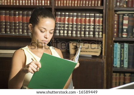 Woman in library reading a book. Horizontally framed photo.