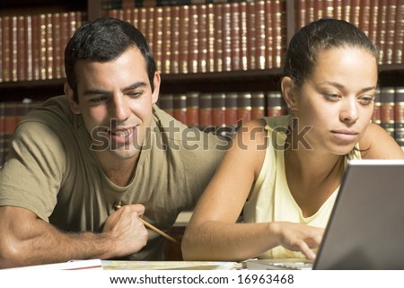 Two Students with laptop in library - Horizontally framed photo.