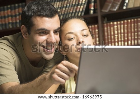 Two students looking at laptop. Horizontally framed photo.