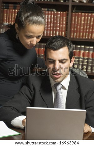 Businessman and woman looking at laptop computer. Vertically framed photo.