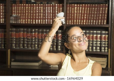 Smiling female student with a light bulb on her head. Horizontally framed photo.