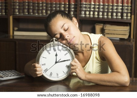 Girl in office sleeping on a clock - Horizontally framed photo.