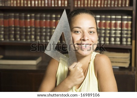 Woman holding drafting tool and smiling. Horizontally framed photo.