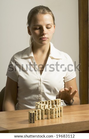 Woman looking thoughtful while playing dominos. Vertically framed photo.