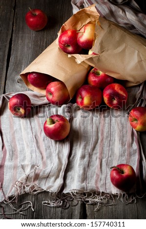 Ripe red apples in a paper bag on the table