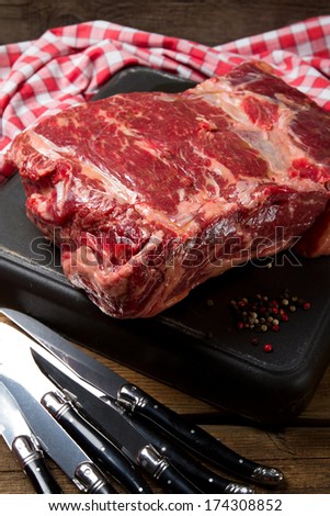 Raw rib eye, pepper and steak knives
