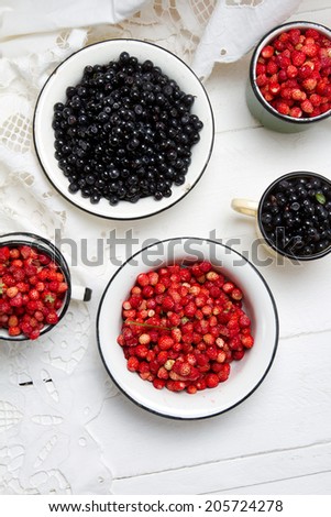 Forest berries: strawberries and blueberries in old bowls