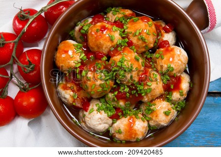 Turkey meatballs with tomato sauce and chives onion in a ceramic pan