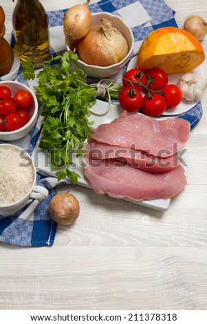 Turkey meat, parsley, tomatoes, onion, pumpkin, garlic and rice on the table