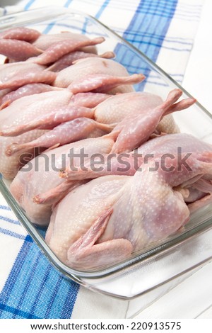 Raw quails in glass dish