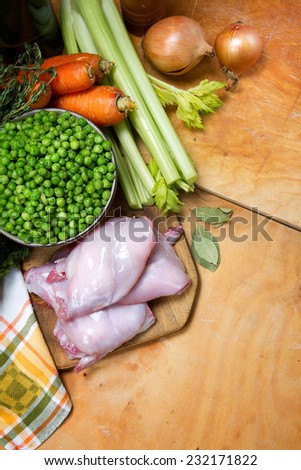 Raw rabbit foot, green peas, carrots, stalk celery, onion, bay leaves and olive oil for stew