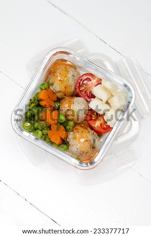 Kids lunch box: stewed peas and carrots, turkey meat balls, cherry tomatoes and goat cheese