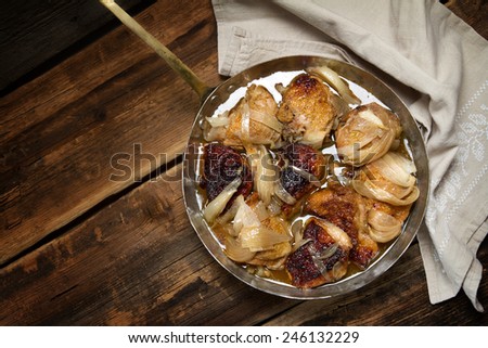 Braised chicken with onions and wine in a copper pan