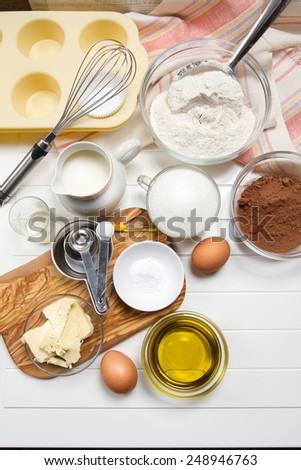 Muffin ingredients: milk, flour, sugar, eggs, butter, olive oil, cocoa powder, baking soda, vanilla extract and vinegar