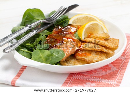 Baked coho salmon, rice pancakes, lemon and young spinach leaves