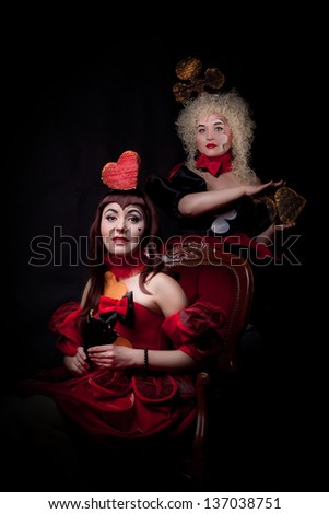 portrait of a queens of hearts and clubs on the dark background