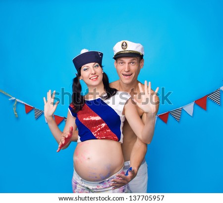 Studio portrait of gay couples during pregnancy, with his hands in the paint