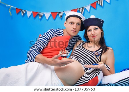 Studio portrait of couple in love during pregnancy in a marine style