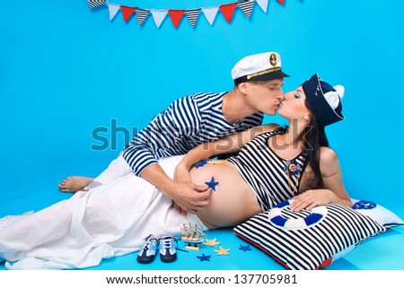 Studio portrait of a couple kissing during pregnancy in a marine style
