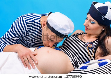 Studio portrait of couple in love during pregnancy in a marine style