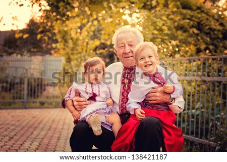 Portrait of grandparents with grandchildren in Ukrainian costume at sunset
