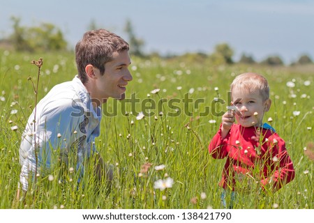 Pictures of father and son in high green grass