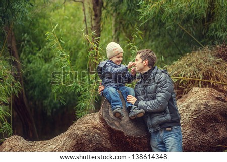 Father and son in a bamboo grove near the huge tree