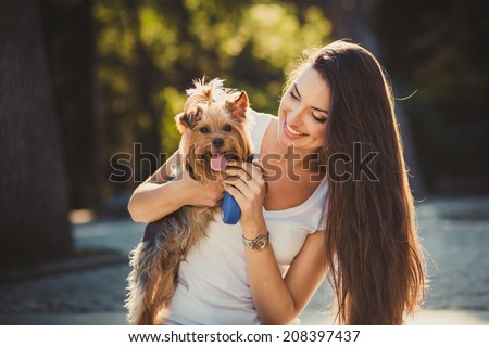 Woman beautiful young happy with long dark hair holding small dog