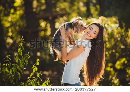 Woman beautiful young happy with long dark hair holding small dog