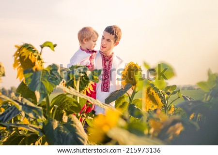 A father and young son in Ukrainian sunflower shirts considering