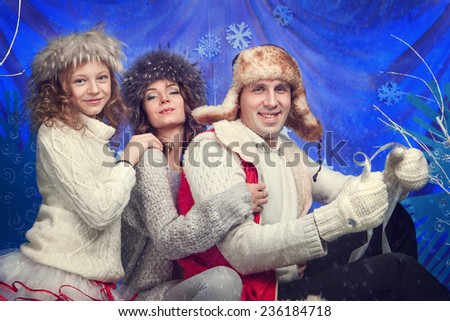Happy family in winter hat, gloves and sweater in studio.