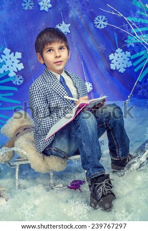 Winter Fashion. Portrait of adorable boy in jacket with book in studio.
