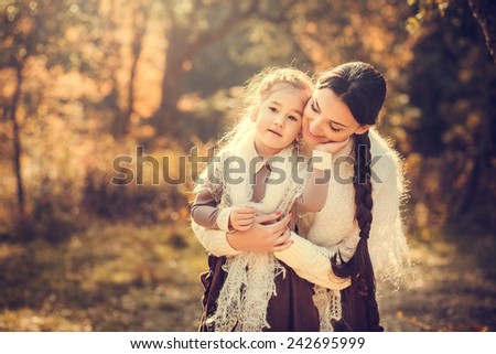 Mother and her daughter in vintage clothes in autumn