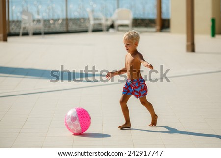 Boy playing with ball on summer playground