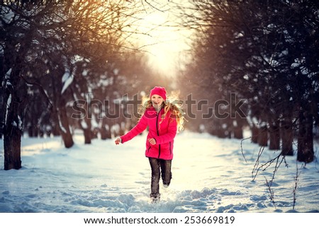 Beauty Teenager Girl Running in frosty winter Park. Outdoors. Sunny day. Backlit.