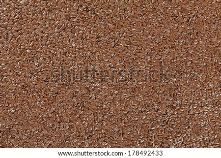 Brown flax seed background. Flax seed is a good source of omega-3 fatty acids, can aid in digestion, and is used to make linseed oil. The plants are used to make linen.