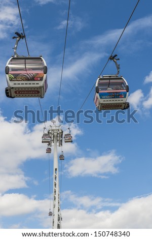 LONDON - AUG 04:Visitors travel on Emirates Air Line cable cars. The service is the UK\'s first urban cable car running across the Thames from the O2 to the Excel Center August 04, 2013 in London UK