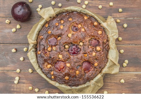 Plum, hazelnuts and chocolate home baked cake glazed with fruit jelly
