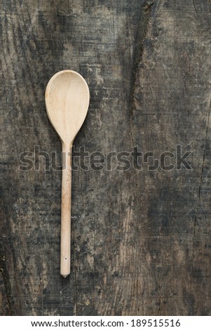 Wooden serving spoon on old rustic wooden board