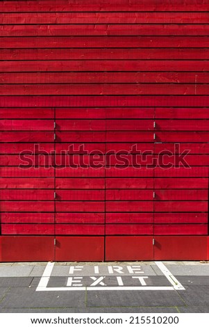 Red door with fire exit painted on the ground