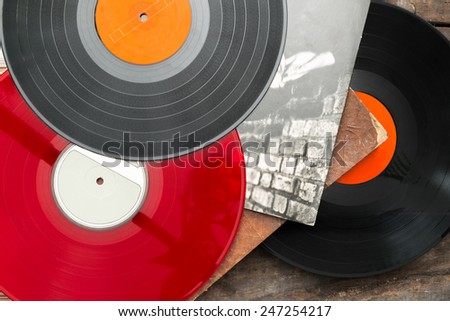 Old vinyl long play records on vintage wooden background.