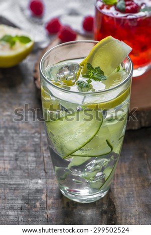 Refreshing summer cocktails - Gin and Tonic with Cucumber and Raspberry Crush in the background