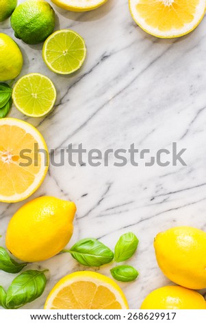 Fresh lime and lemon citrus fruits on marble background. Copy paste your own text. Empty space next to yellow and green juicy fresh fruits on white bakground.