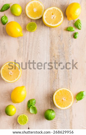 Fresh lime and lemon citrus fruits on wooden background. Copy and paste your own text. Empty space next to yellow and green juicy fruits on warm wooden bakground.